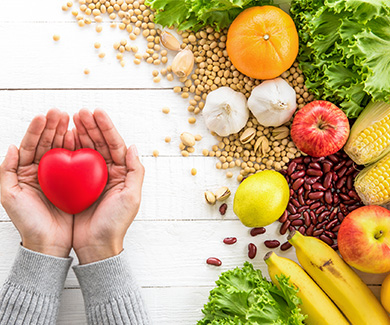 A woman hands showing red heart ball with healthy food