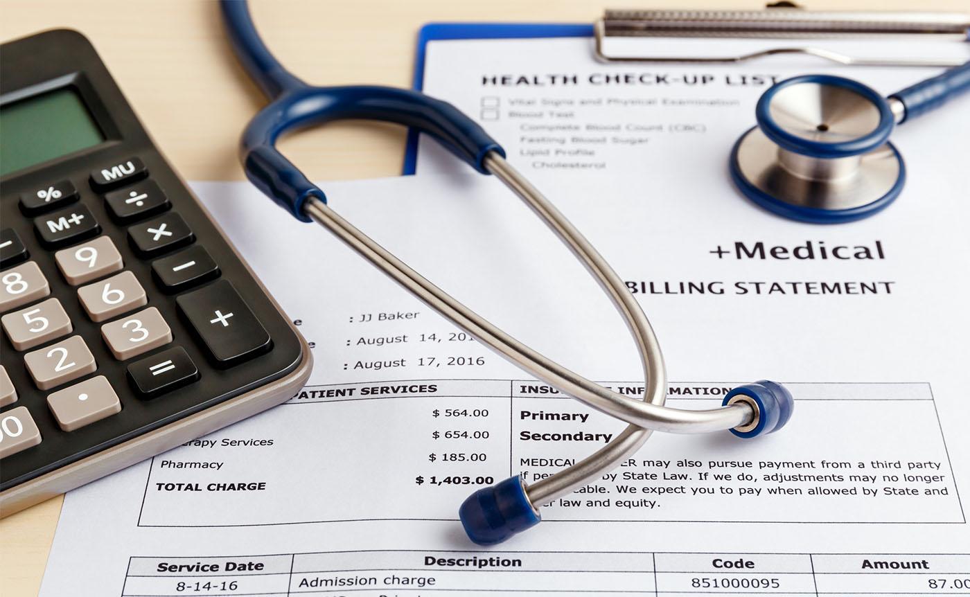 A stethoscope and calculator are lying on the medical billing statement