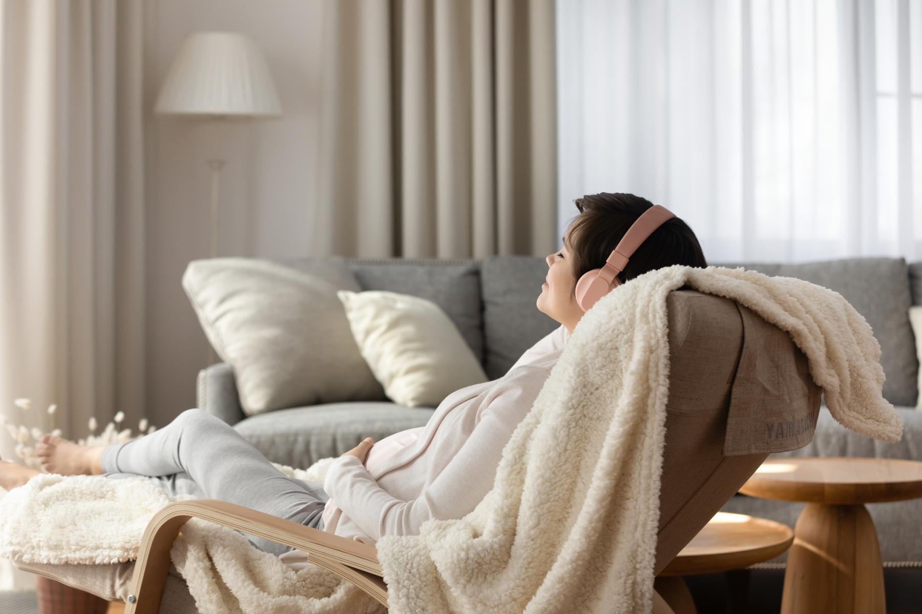 A female relaxing on the chair with her headphone on
